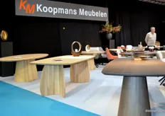 Nico Satter van Koopmans Meubelen in gesprek met een bezoeker. Op de voorgrond staan drie nieuwe tafels.